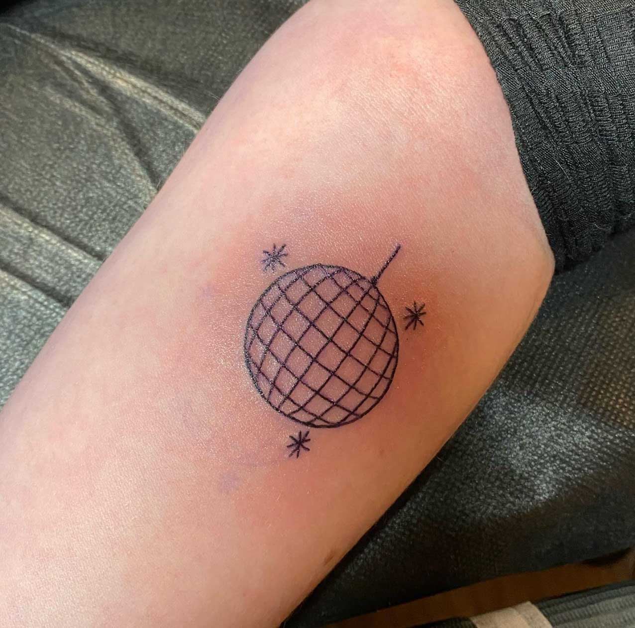 Single needle disco ball tattoo on the inner forearm